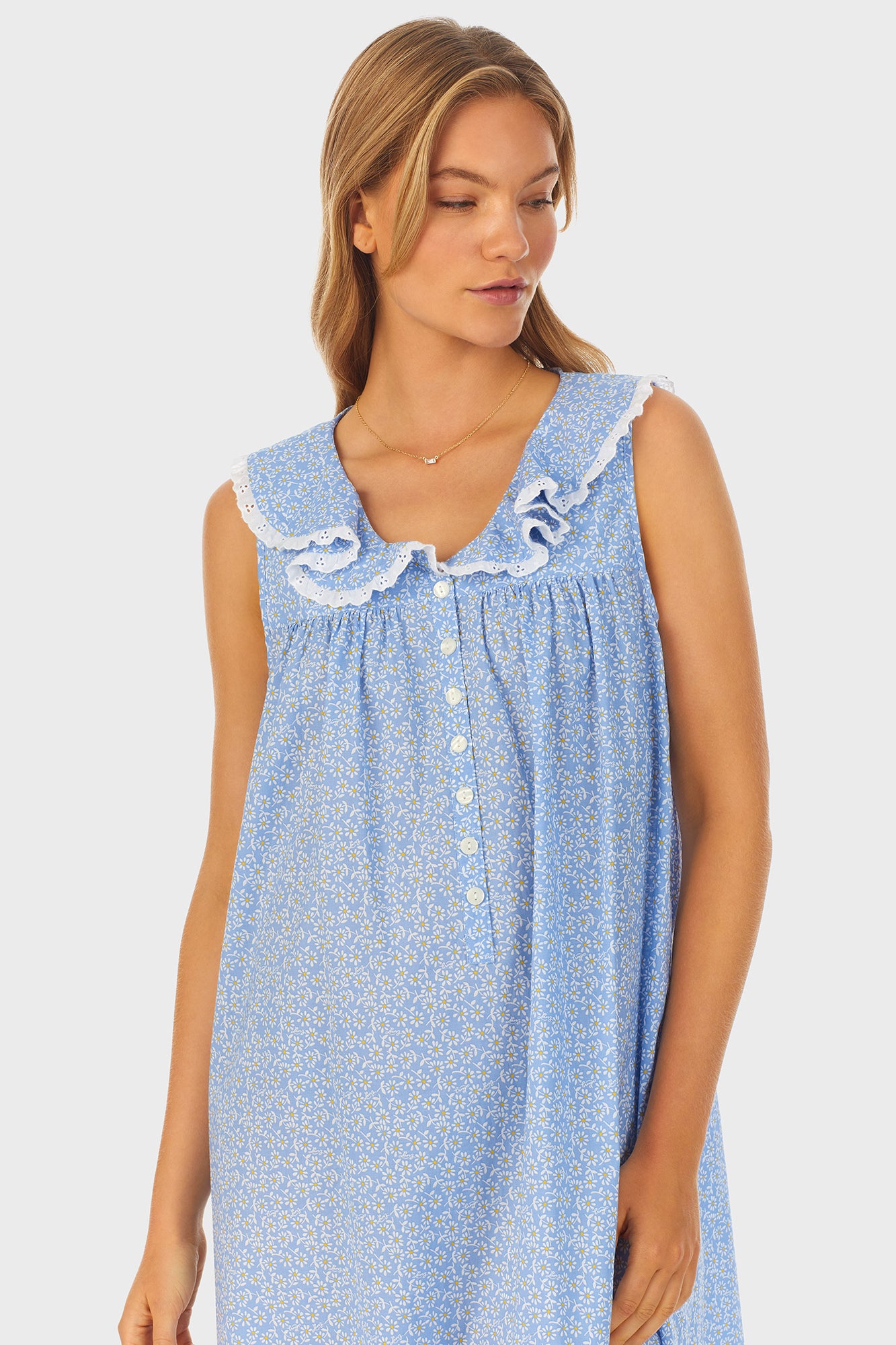  A lady wearing blue long nightgown with a white pattern.