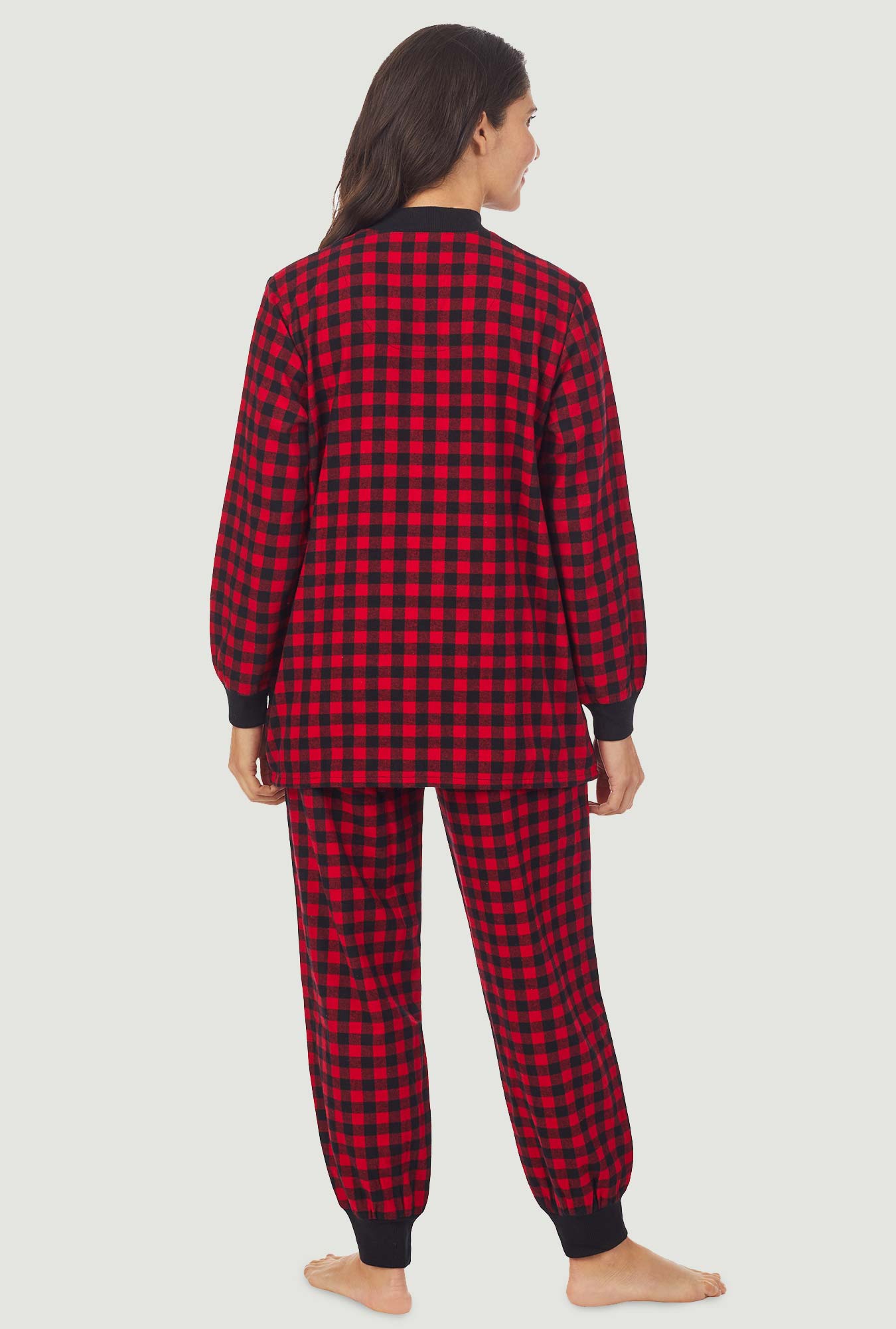 A lady wearing a red buffalo check long sleeve ski pajama.