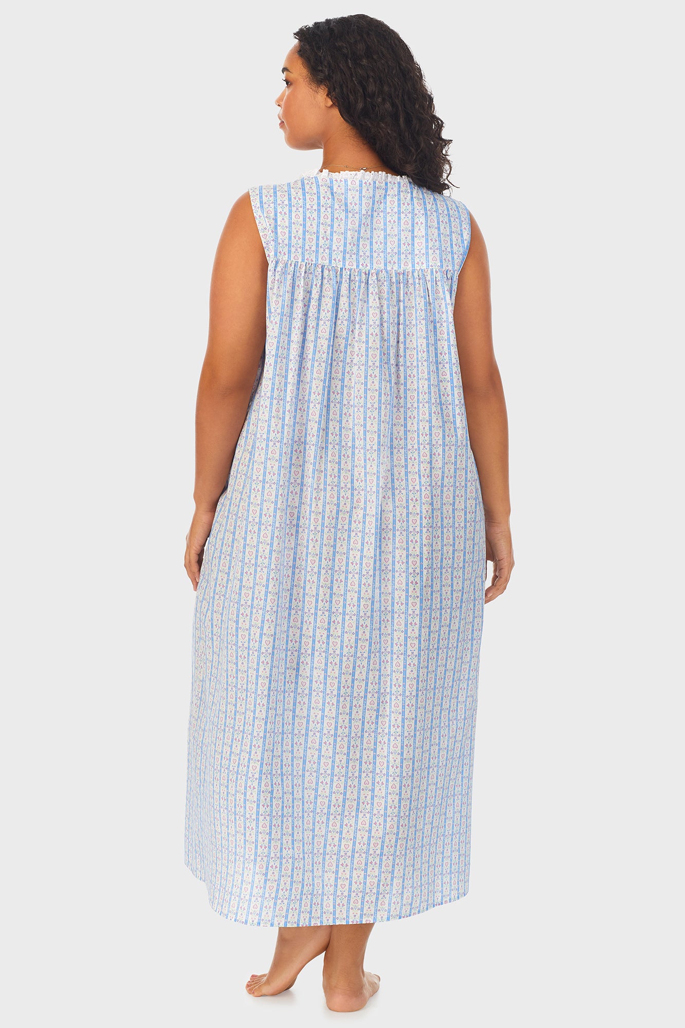 A lady wearing white long nightgown with blue pattern