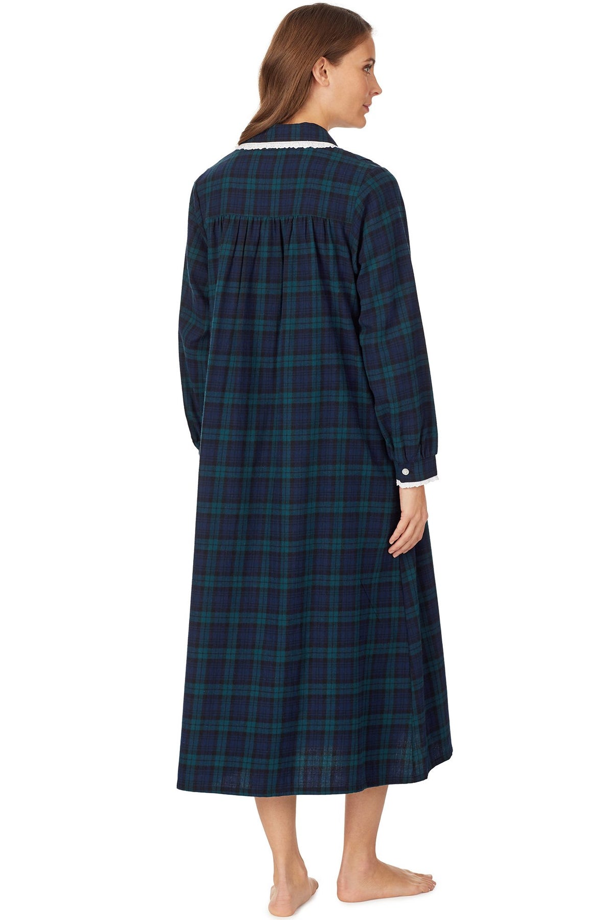 A lady wearing a long sleeve flannel gown petite with black watch plaid pattern.