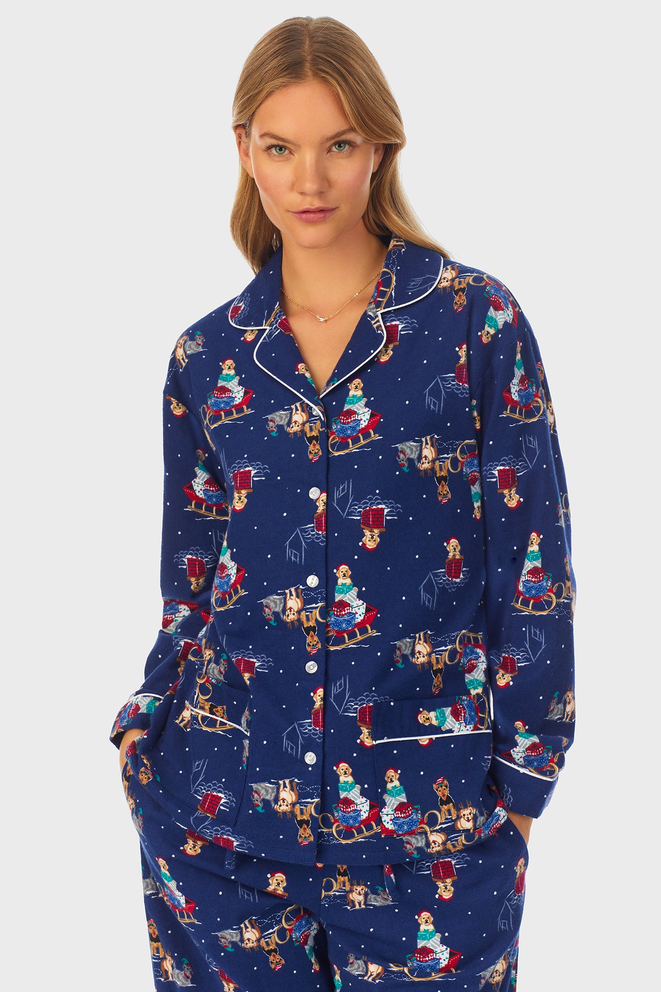 A lady wearing navy long sleeve women's pajama with sleigh puppies print.